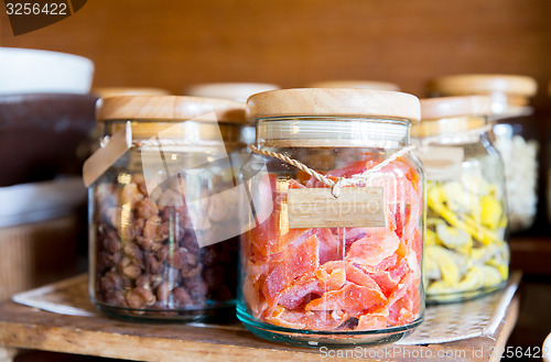 Image of close up of jars with dried fruits at grocery