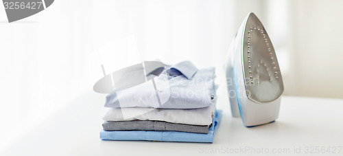 Image of close up of iron and clothes on table at home