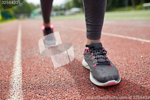 Image of close up of woman feet running on track from back