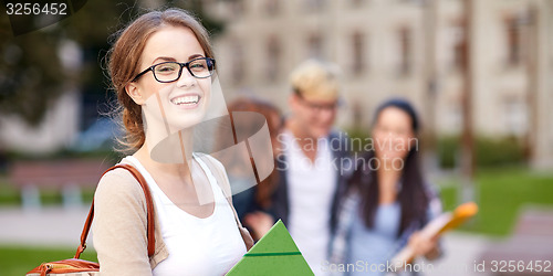 Image of happy teenage students with school folders