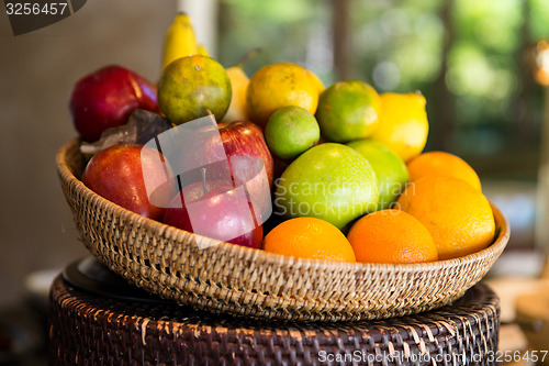 Image of basket of fresh ripe juicy fruits at kitchen