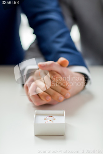 Image of close up of male gay couple and wedding rings