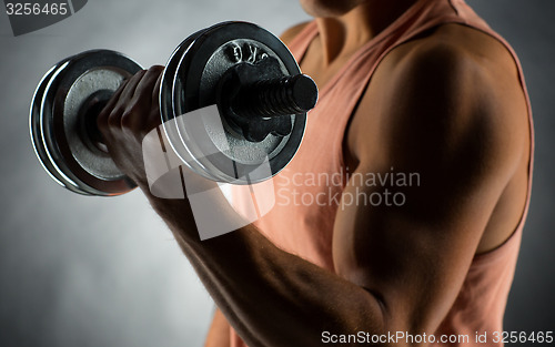 Image of close up of young man with dumbbell