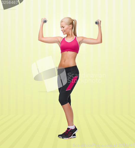 Image of young sporty woman with dumbbells