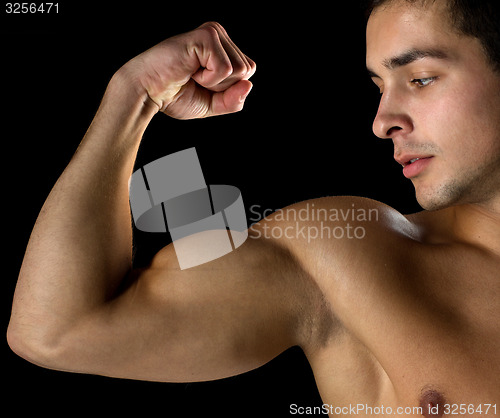 Image of close up of young man showing biceps
