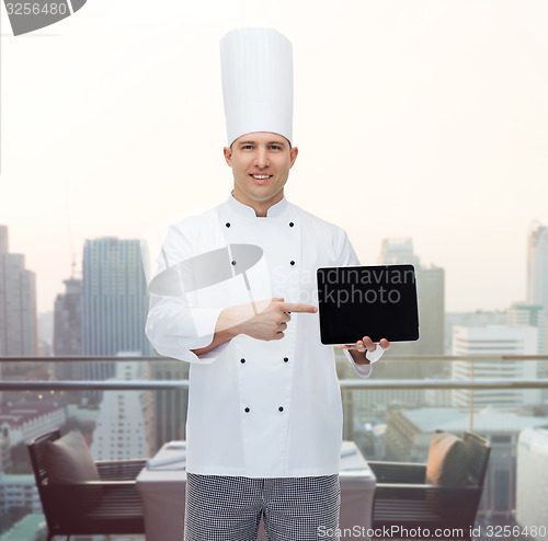 Image of happy male chef cook showing with tablet pc
