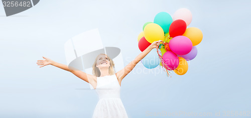 Image of woman with colorful balloons outside