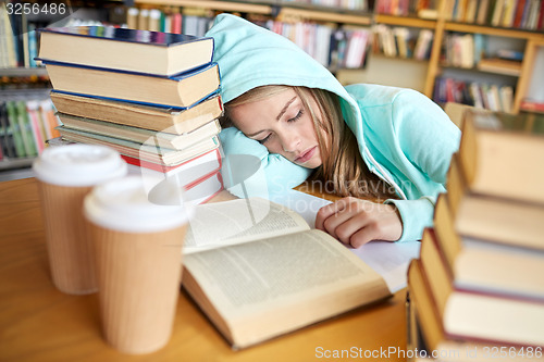 Image of student or woman with books sleeping in library