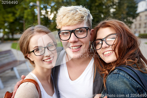 Image of happy teenage students in eyeglasses at campus