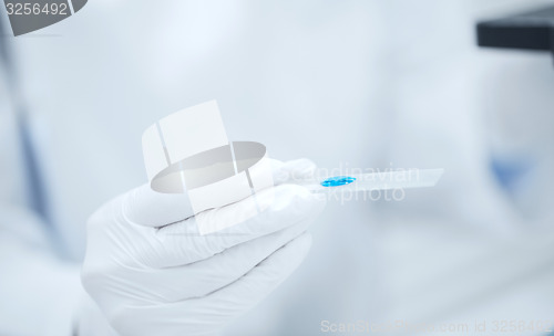 Image of close up of scientist hand with test sample in lab