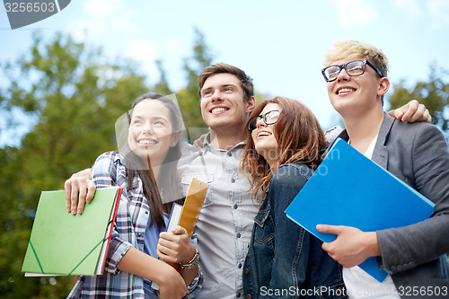 Image of group of happy students with folders outdoors