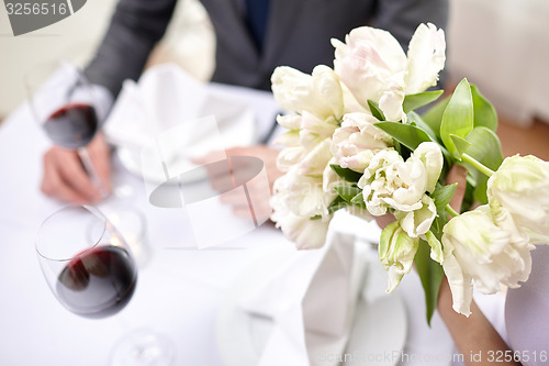 Image of close up of couple with flowers at restaurant
