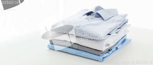 Image of close up of ironed and folded shirts on table