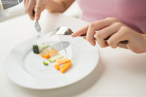 Image of close up of woman hands eating vegetables
