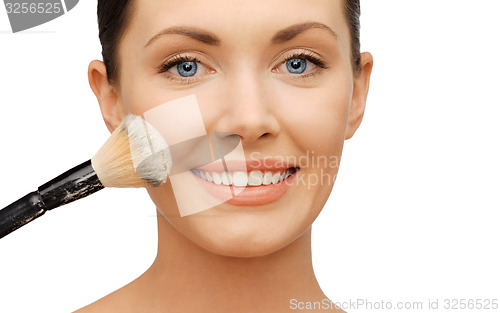 Image of woman applying powder foundation with brush