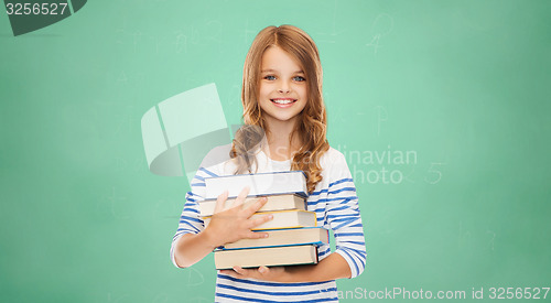 Image of happy little student girl with many books