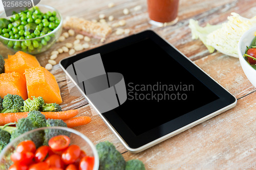 Image of close up of blank tablet pc screen and vegetables