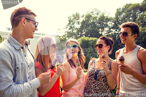 Image of group of smiling friends with ice cream outdoors