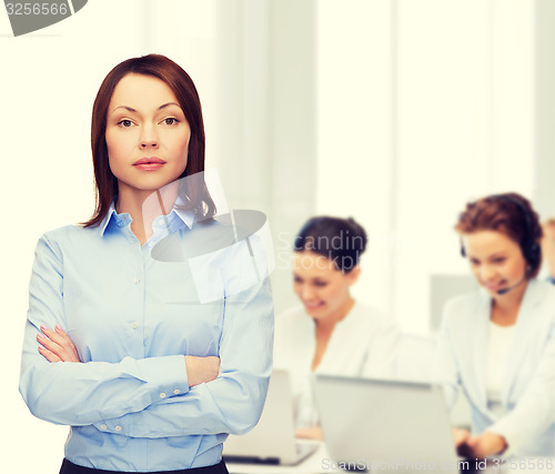 Image of smiling businesswoman with crossed arms at office