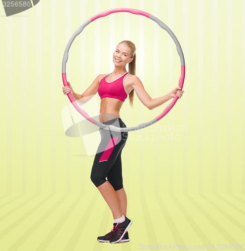 Image of young sporty woman with hula hoop