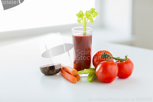 Image of close up of fresh juice and vegetables on table