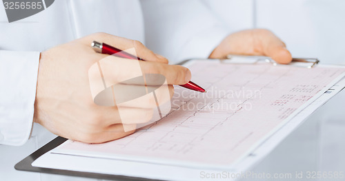 Image of male doctor hands holding cardiogram