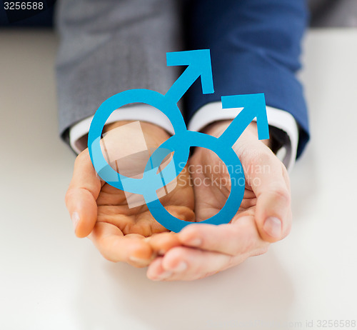 Image of close up of happy male gay couple with love symbol