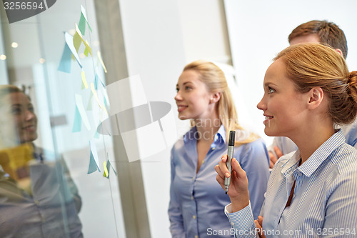 Image of smiling business people with marker and stickers