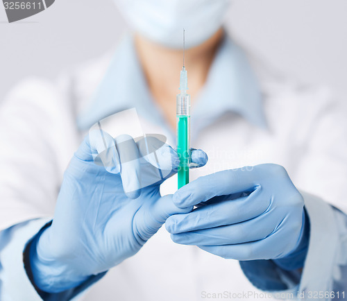 Image of female doctor holding syringe with injection