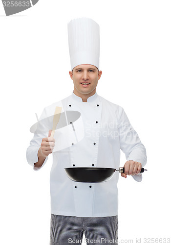 Image of happy male chef holding frying pan and spatula