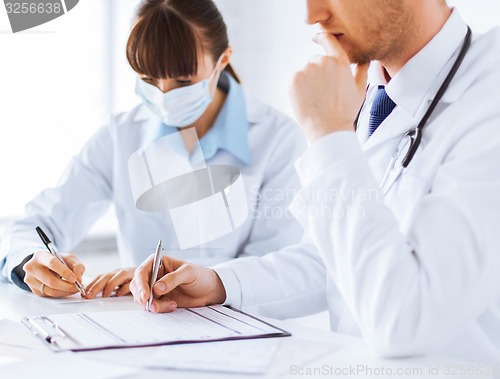 Image of doctor and nurse writing prescription paper
