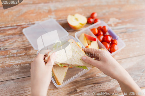 Image of close up of woman with food in plastic container