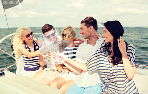 Image of smiling friends with glasses of champagne on yacht