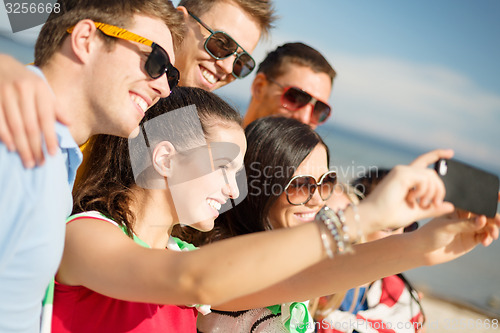 Image of group of friends taking selfie with cell phone