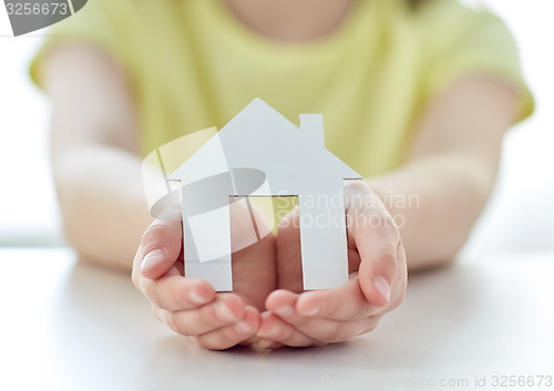 Image of close up of happy girl hands holding paper house