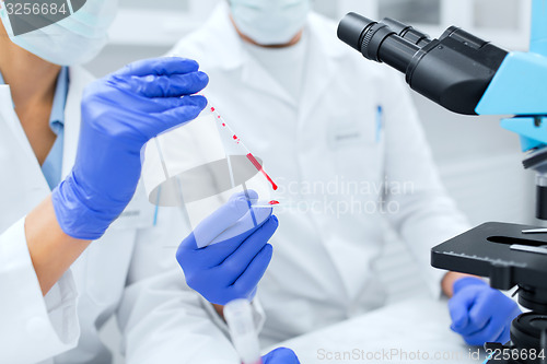 Image of close up of scientists filling perti dish in lab