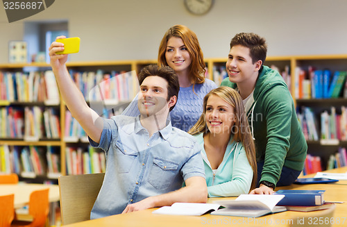 Image of students with smartphone taking selfie at library
