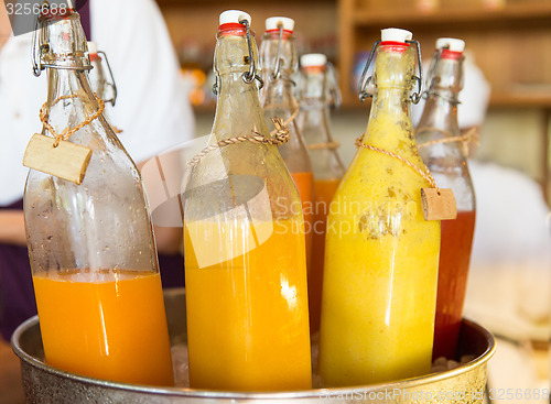 Image of bottles of juice in ice bucket at market