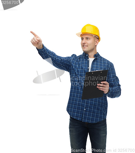 Image of smiling man in helmet with clipboard