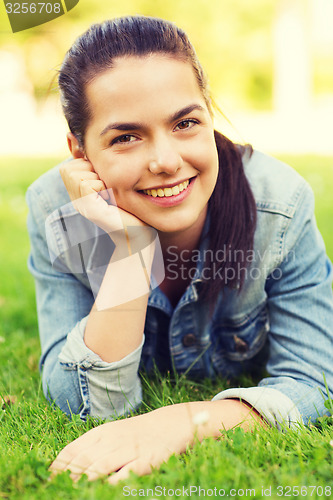 Image of smiling young girl lying on grass