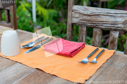 Image of close up of cutlery with glass and napkin on table