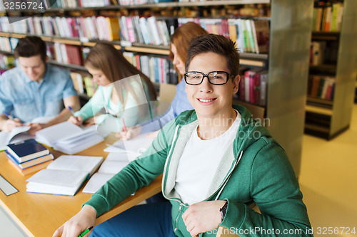 Image of happy student boy reading books in library