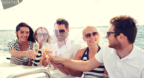 Image of smiling friends with glasses of champagne on yacht