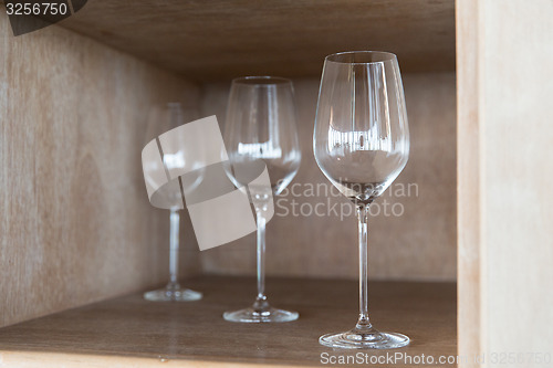 Image of empty wine glasses set on shelf at restaurant