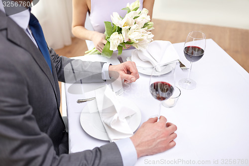 Image of close up of couple with flowers at restaurant
