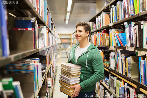 Image of happy student or man with book in library