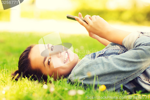 Image of smiling young girl lying on grass