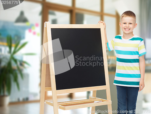 Image of happy little boy with blank blackboard