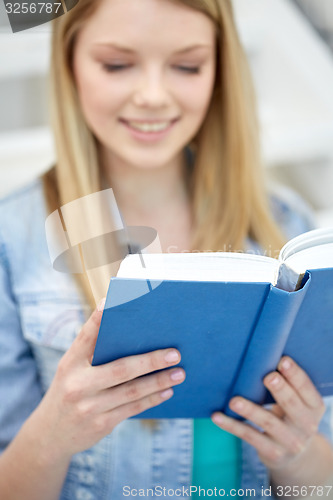 Image of close up of young woman reading book at school