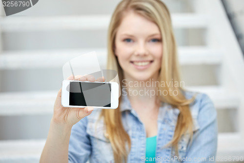 Image of close up of happy teenage girl showing smartphone